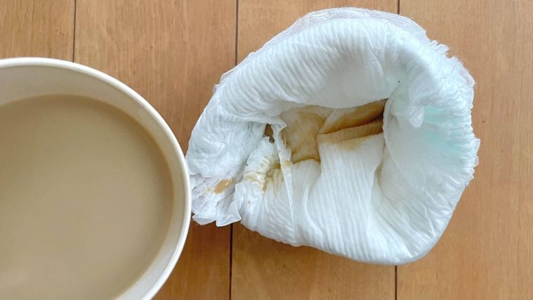 袋状にしたおむつに液体を入れている様子