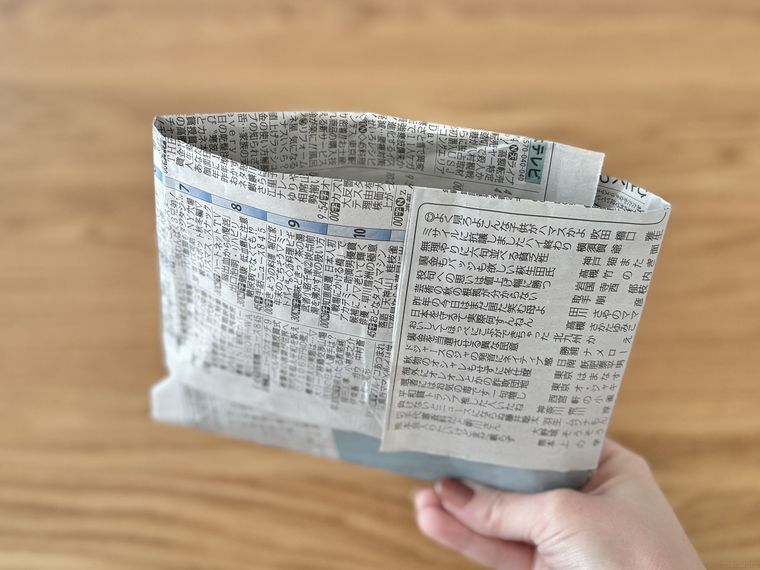 新聞紙で作った紙袋を手で持っている様子