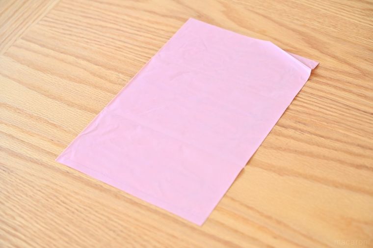 木のテーブルに広げたピンク色の袋