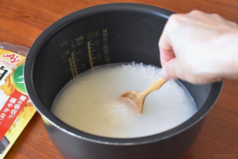 スプーンを添えた炊飯器の中の米