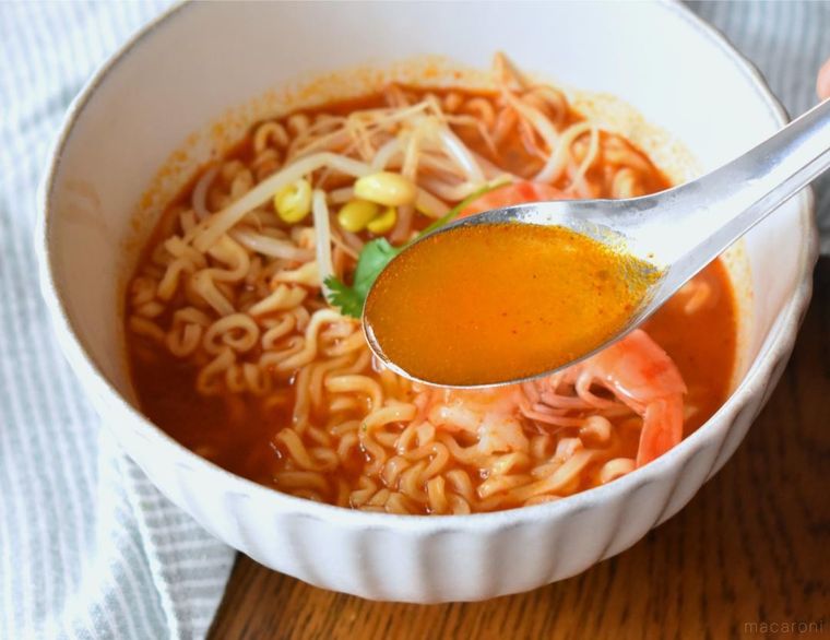 れんげですくったトムヤムクンヌードルのスープ