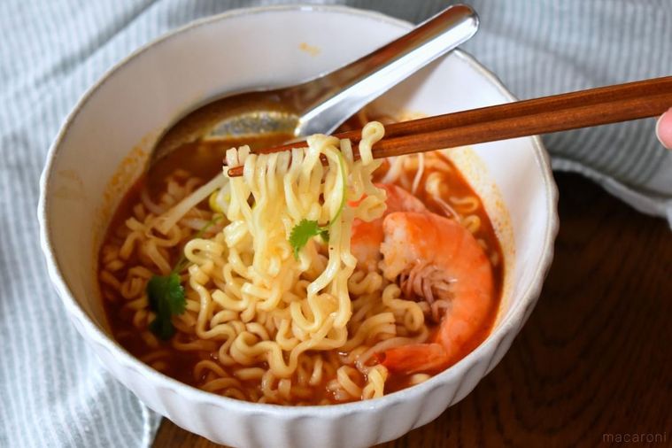 箸で持ち上げたトムヤムクンヌードルのめん