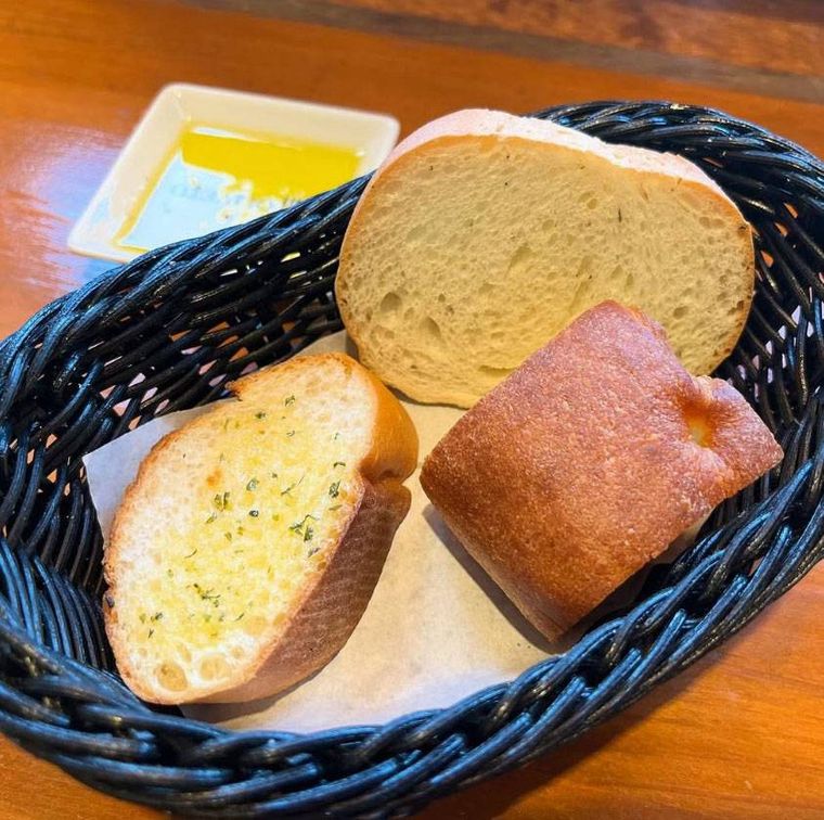 黒いかごに入った「ランチセット」のパンとオリーブオイル