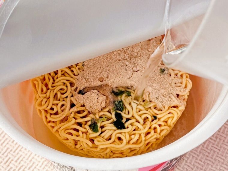 「超大盛りスーパーカップ2.0倍 たらこ注意報 たらこ味塩ラーメン」にお湯を注いでいる様子