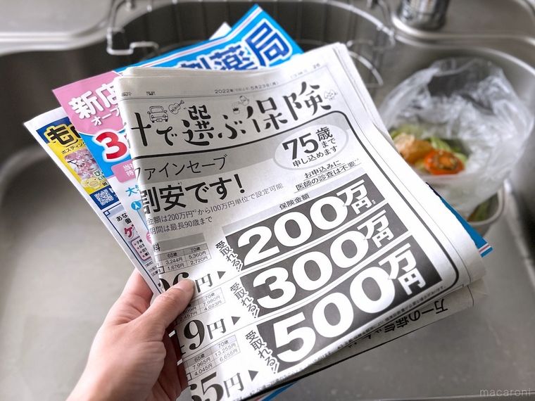 新聞紙とチラシを手で持っている様子