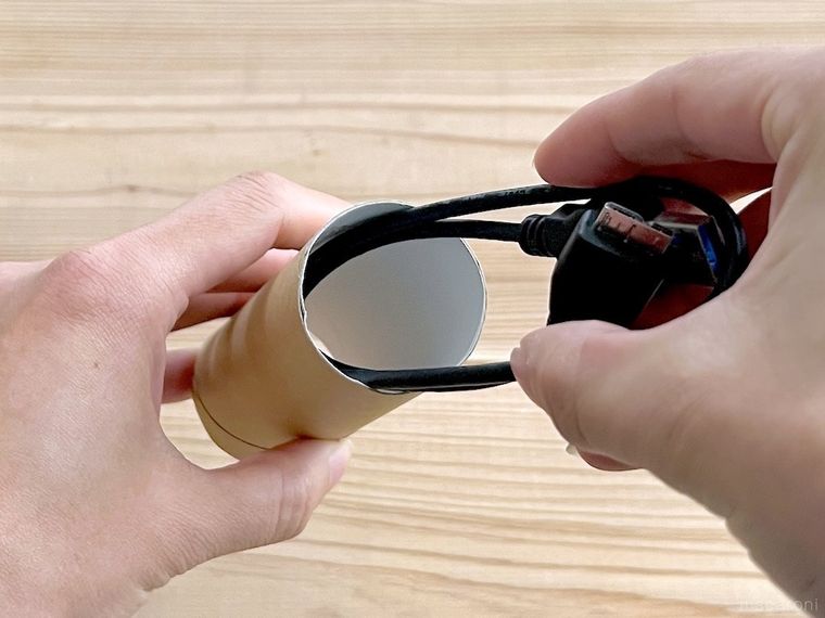コードをトイレットペーパーの芯に入れている様子