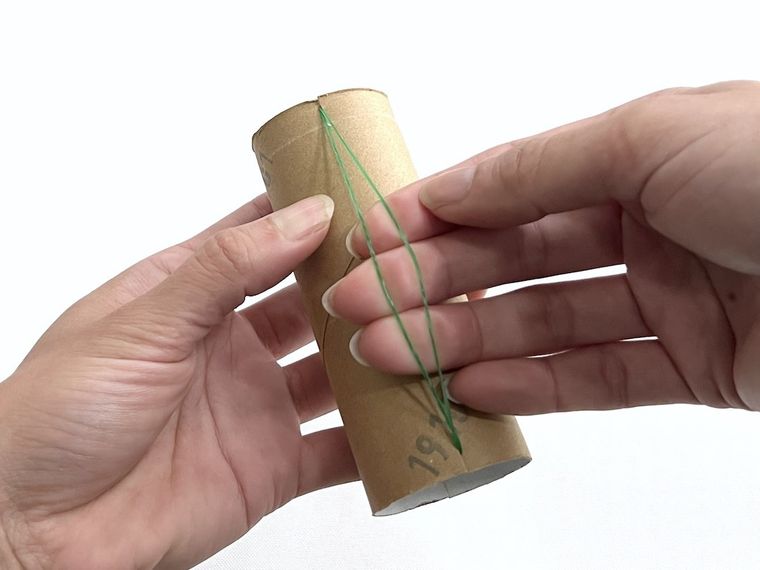 トイレットペーパーの芯に輪ゴムをはめている様子