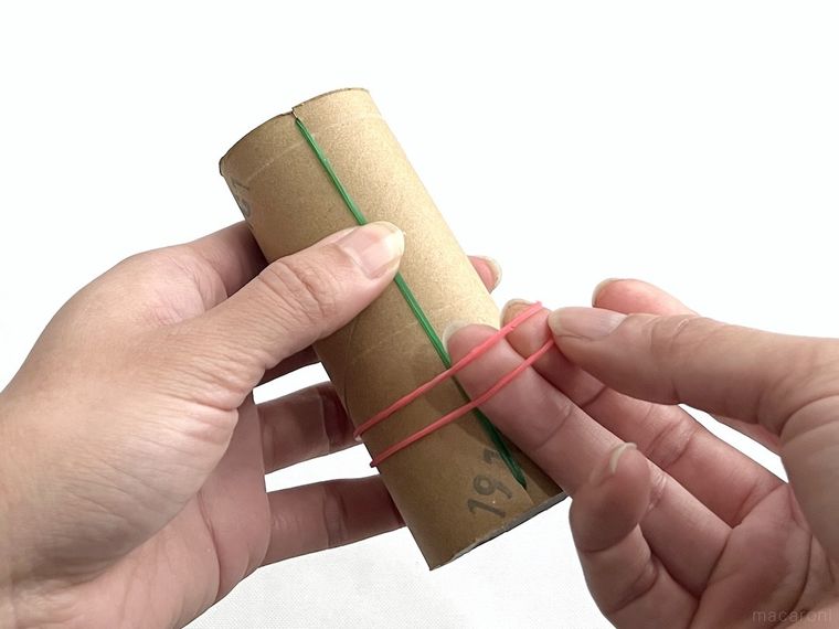 トイレットペーパーの芯に輪ゴムをはめている様子