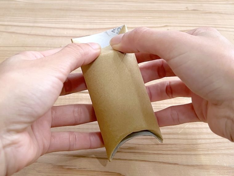 トイレットペーパーの芯の端を折っている様子