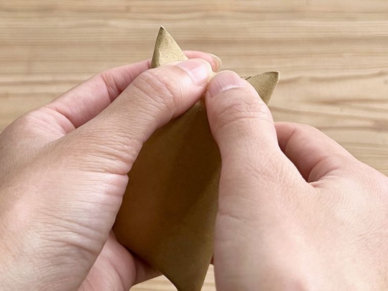 トイレットペーパーの芯の端を折っている様子