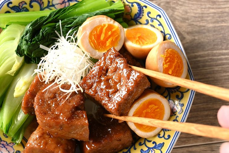 豚角煮風をひと切れ箸で摘む様子