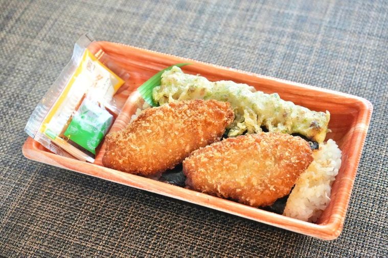 茶色いランチョンマットと白身魚のフライとちくわの磯辺揚げときんぴらごぼうとタルタルソースがのったのり弁当