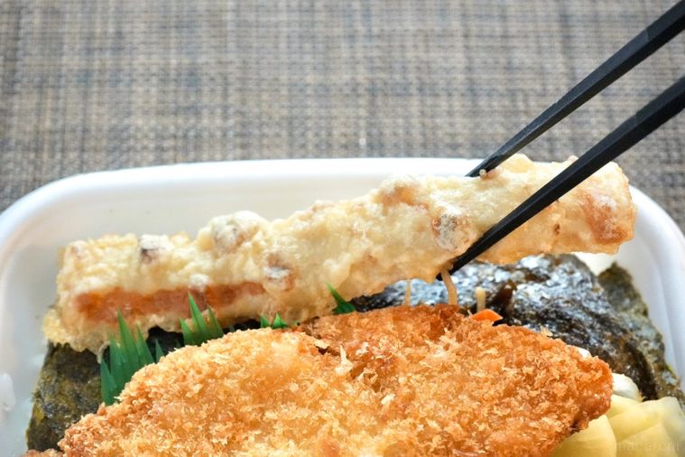 白身魚のフライがのったのり弁当のちくわ磯辺揚げを黒い箸で持ち上げる様子