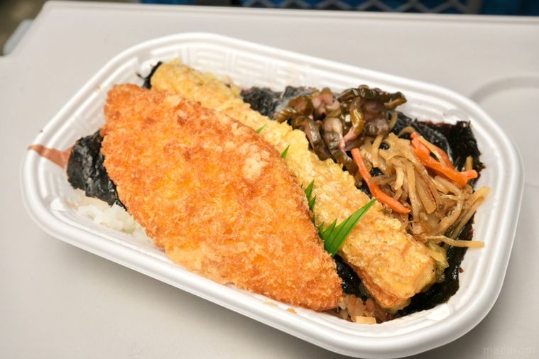 白いトレーの白身魚のフライとちくわ天ときんぴらごぼうとしば漬けがのったのり弁当