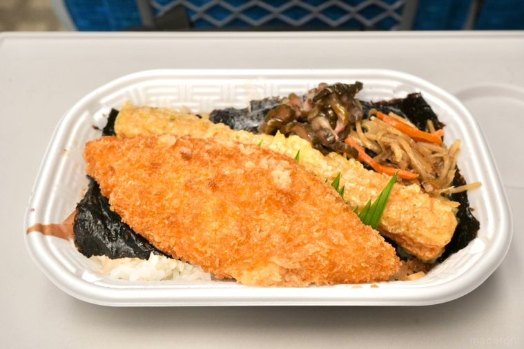 白いトレーの白身魚のフライとちくわ天ときんぴらごぼうとしば漬けがのったのり弁当