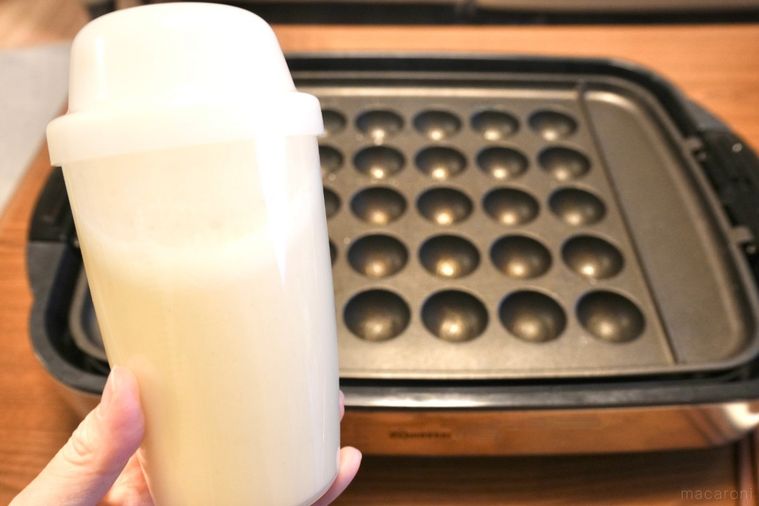 たこ焼き器とプロテインシェイカーに入ったたこ焼き生地を手に持つ様子