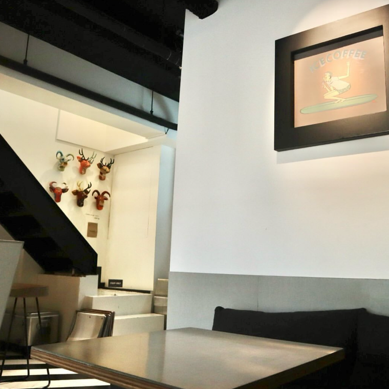 黒のソファー、ウッディなテーブルがあるスタイリッシュな店内