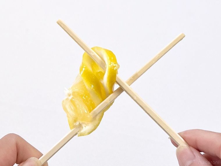 スライスレモンを箸で搾っている様子