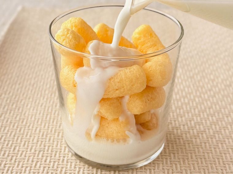 グラスに入った「バナナキック」に牛乳を注いでいる様子