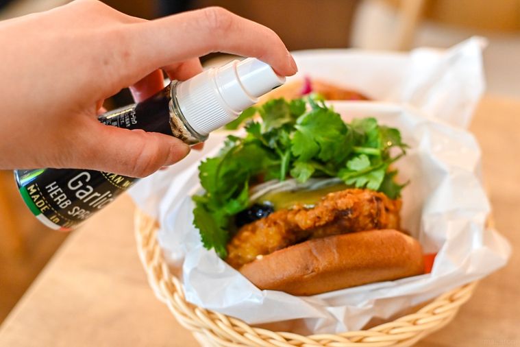 バーガーにスパイスをかけているところ