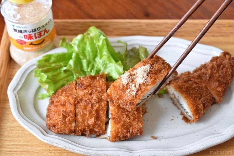 味ぽんスパイスをかけて箸で持ち上げた魚のフライ