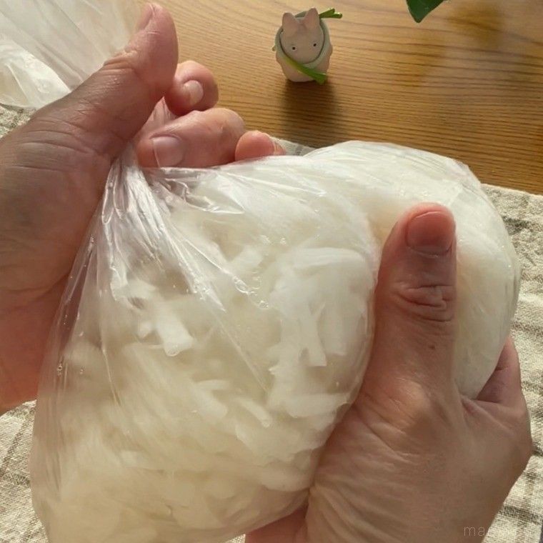 ポリ袋に入った千切りの大根を塩もみする様子