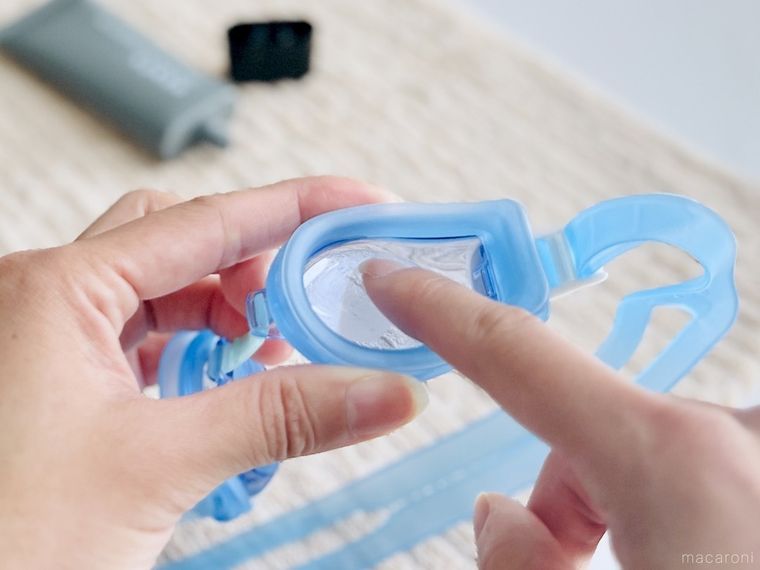 水泳用ゴーグルのレンズにハンドクリームを塗っている様子