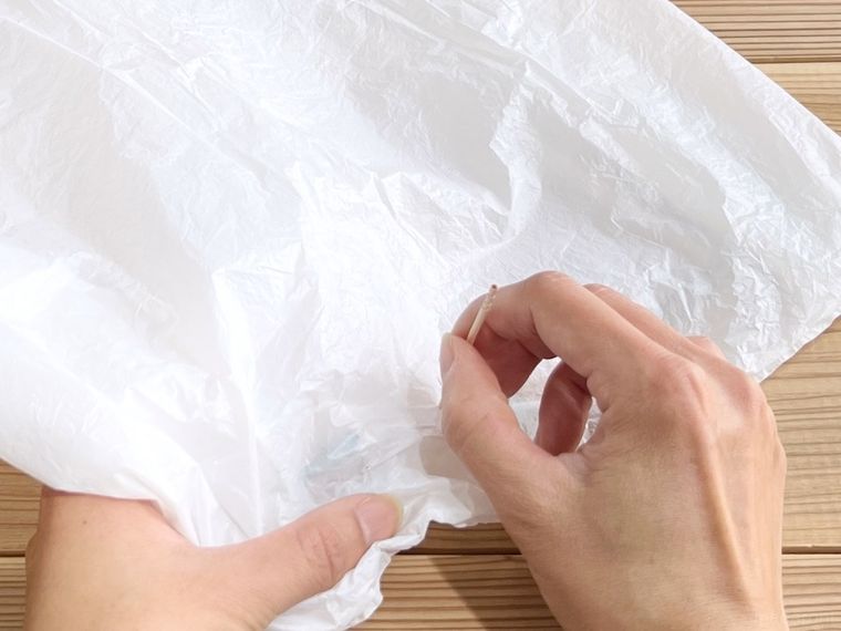 ポリ袋につまようじで穴を開けている様子