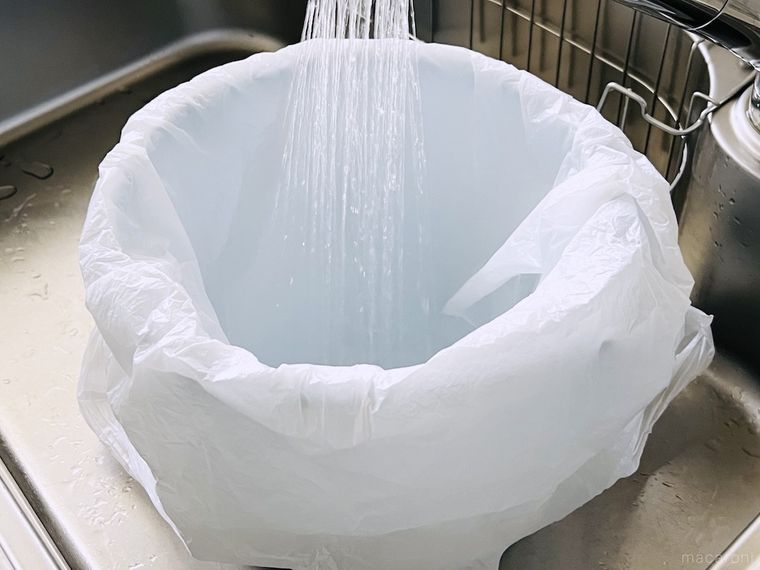 ポリ袋をかぶせたバケツに水を入れている様子