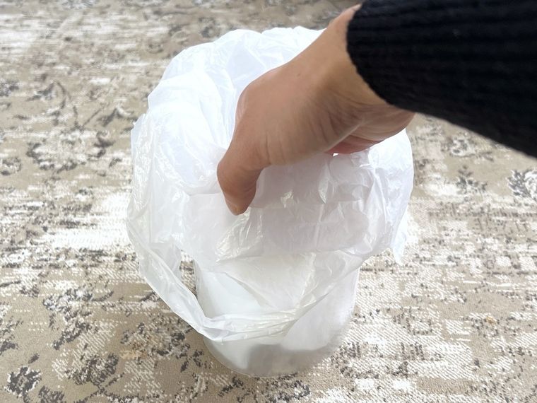 丸めたクリアファイルにポリ袋をかぶせている様子
