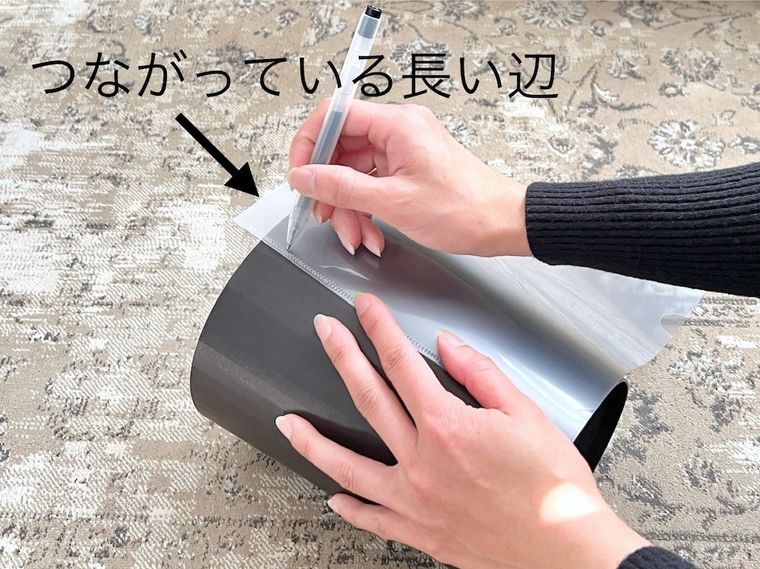 クリアファイルをゴミ箱に当てて印をつけている様子