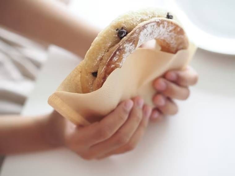 コーヒーフィルターに入ったドーナツを手で持っている様子
