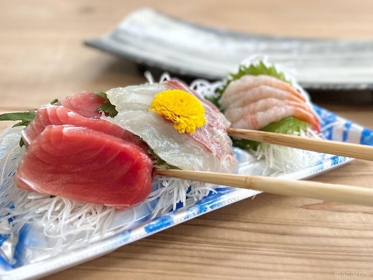 刺身を皿に盛り付けようとしている様子