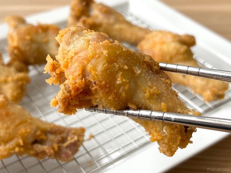 鶏手羽元の唐揚げを箸で持ち上げている様子