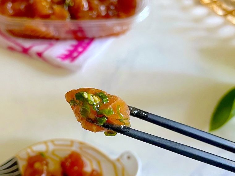 コストコのマグロポキを少量小皿にとって、1個箸で持ち上げたところ