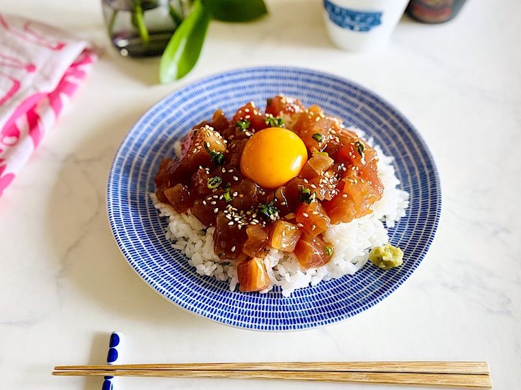 コストコのマグロポキを白ごはんと一緒にブルーの器に盛り付け、真ん中に卵黄をのせたマグロポキ丼