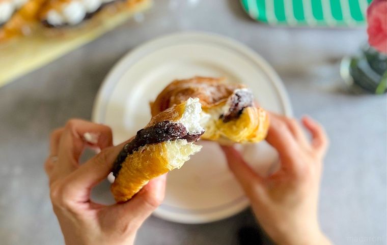 コストコのあんホイップクロワッサンを1個手にとり、半分にちぎっているところ