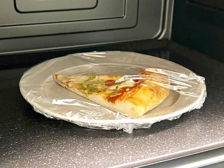 電子レンジでピザを温め直している様子