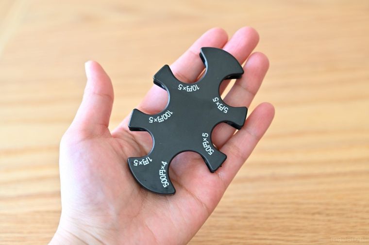 黒いコインホルダーを手のひらにのせている