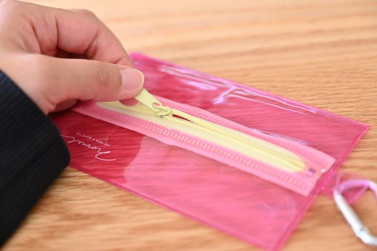 ピンクのポーチについているファスナーを触っている