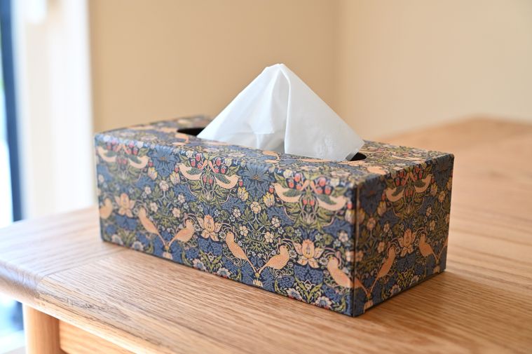 木のテーブルに置かれた華やかデザインのティッシュケース
