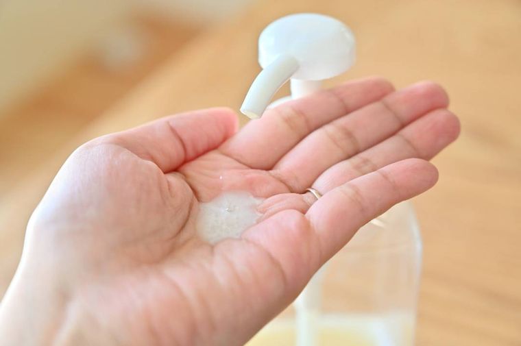 シャンプーボトルと手のひらに出た少量のシャンプー