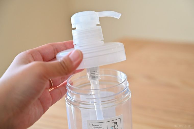 シャンプーボトルの本体から上部をはずしている