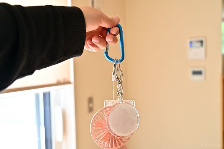 小物を通したカラビナを手に持っている