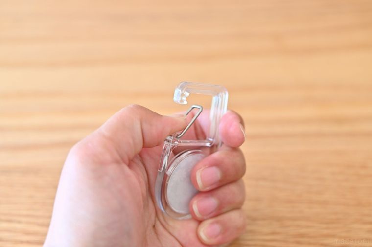 透明カラビナの開閉部分を親指で押している