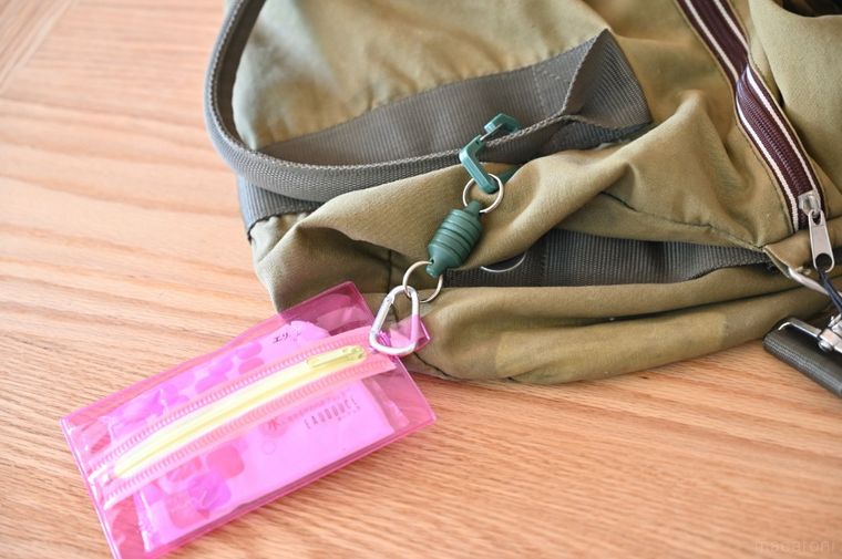 グリーンのバッグにピンクのティッシュケースがついている