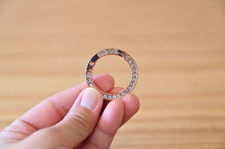 キラキラのストーンが入った丸型カラビナを手に持っている