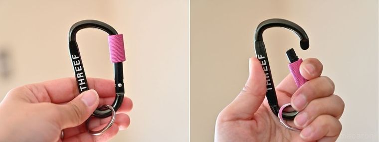 ピンクのロックがついた黒いカラビナを手に持って開閉している