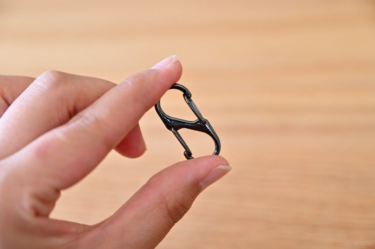 コンパクトな金属製S字カラビナを手に持っている