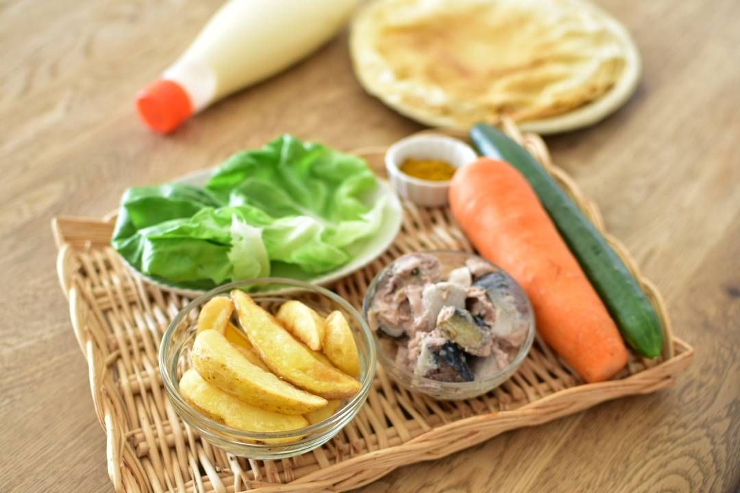 テーブルで彩り野菜とサバのフライズ・ラップを作っている様子